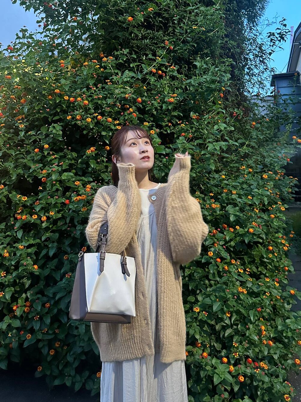 ホワイト系のシャツ/ブラウス、ベージュ系のカーディガン/ボレロ、ホワイト系のトートバッグを着用したレディースの秋コーディネートの3枚目の写真