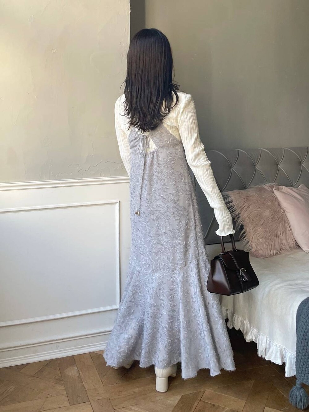 ブラウン系のハンドバッグ、ホワイト系のブーツ、ホワイト系のTシャツ/カットソーを着用したレディースの冬コーディネートの2枚目の写真