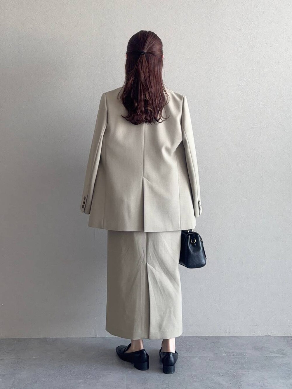 ブラック系のローファー、ブラック系のショルダーバッグ、ベージュ系のテーラードジャケットを着用したレディースの冬コーディネートの2枚目の写真