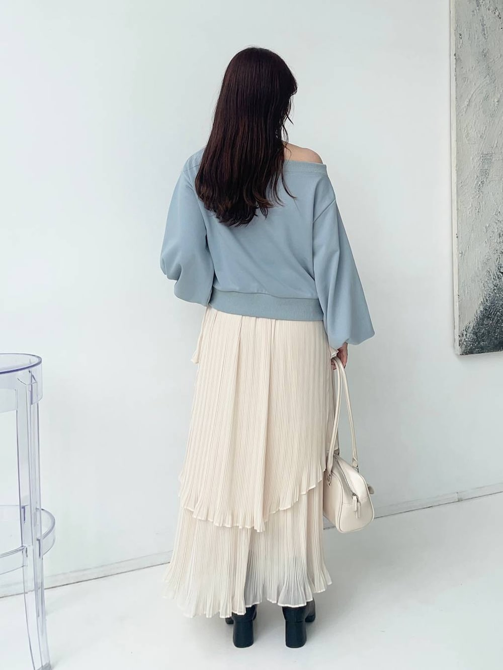 ブラック系のブーツ、ブルー系のスウェット、ホワイト系のスカートを着用したレディースの秋コーディネートの2枚目の写真