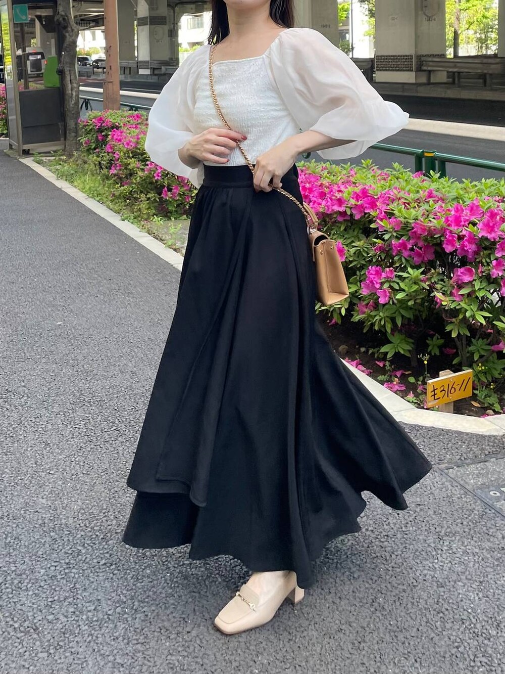 ホワイト系のTシャツ/カットソー、ブラック系のスカート、ブラウン系のショルダーバッグを着用したレディースの春コーディネートの5枚目の写真