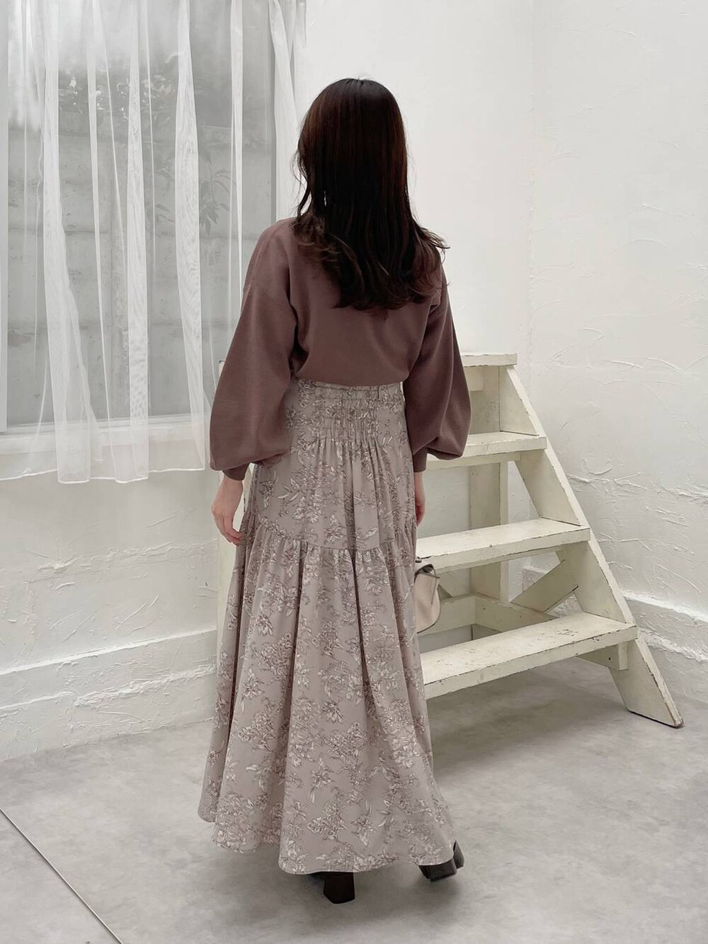 ホワイト系のハンドバッグ、ブラウン系のニット/セーター、ブラウン系のブーツを着用したレディースの冬コーディネートの2枚目の写真