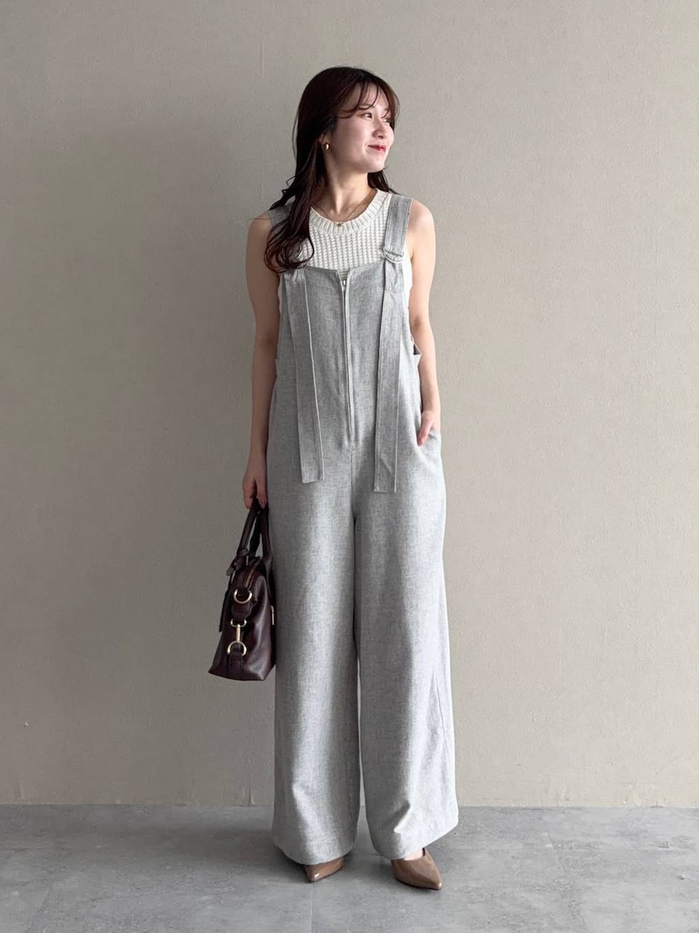 グリーン系のパーカー、ブラウン系のボストンバッグ、ブラウン系のサンダルを着用したレディースの春コーディネートの4枚目の写真