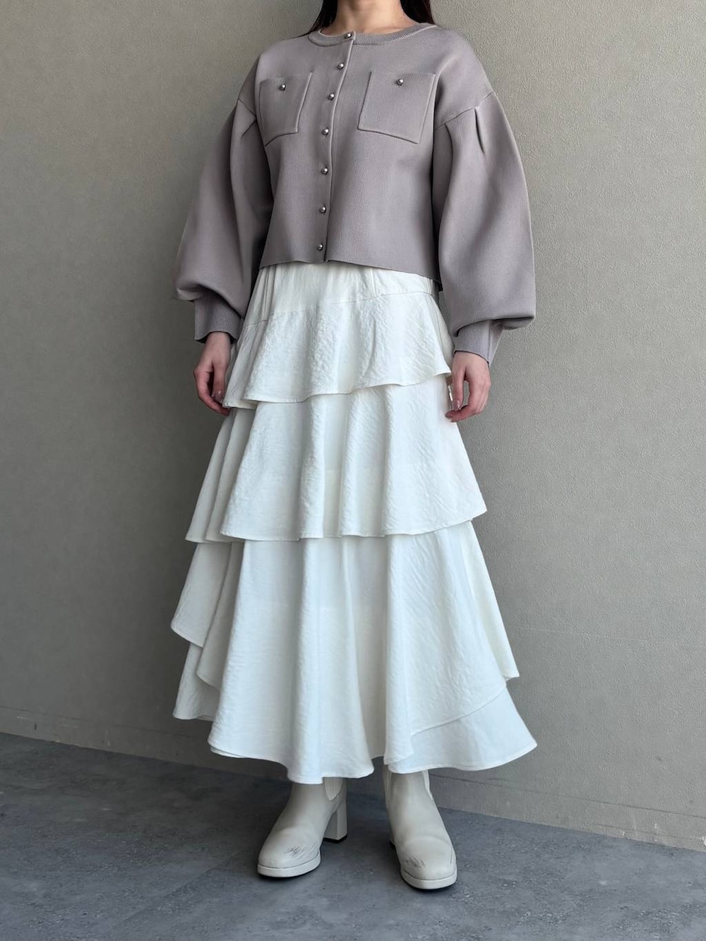 ホワイト系のブーツ、ホワイト系のショルダーバッグ、ベージュ系のカーディガン/ボレロを着用したレディースの春コーディネートの4枚目の写真