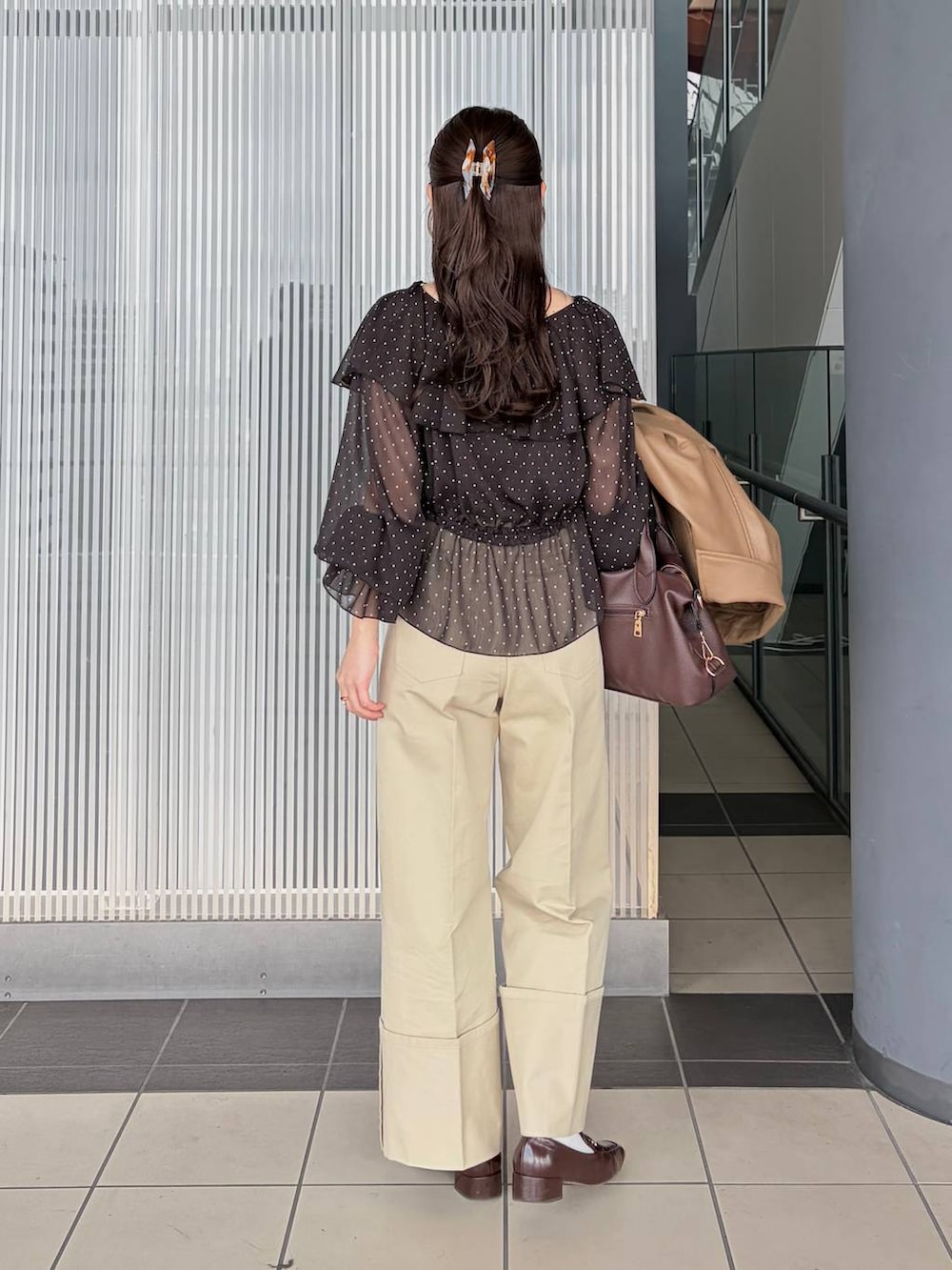 ブラウン系のボストンバッグ、ブラウン系のブルゾン、ブラック系のシャツ/ブラウスを着用したレディースの春コーディネートの4枚目の写真