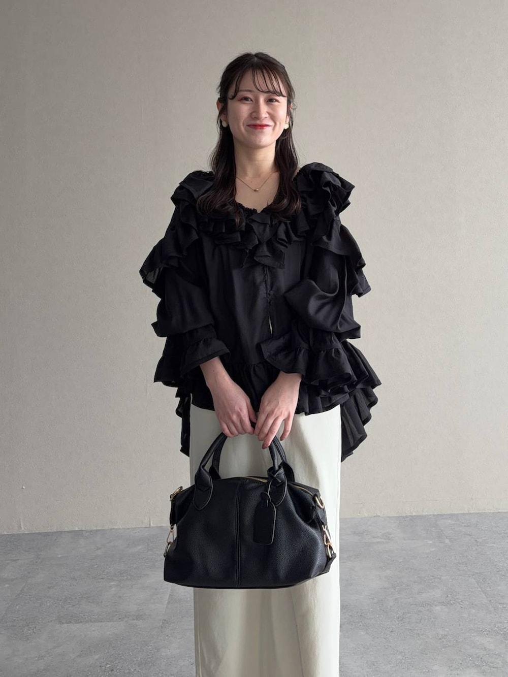 ブラック系のボストンバッグ、ブラック系のシャツ/ブラウス、ホワイト系のスカートを着用したレディースの春コーディネートの3枚目の写真