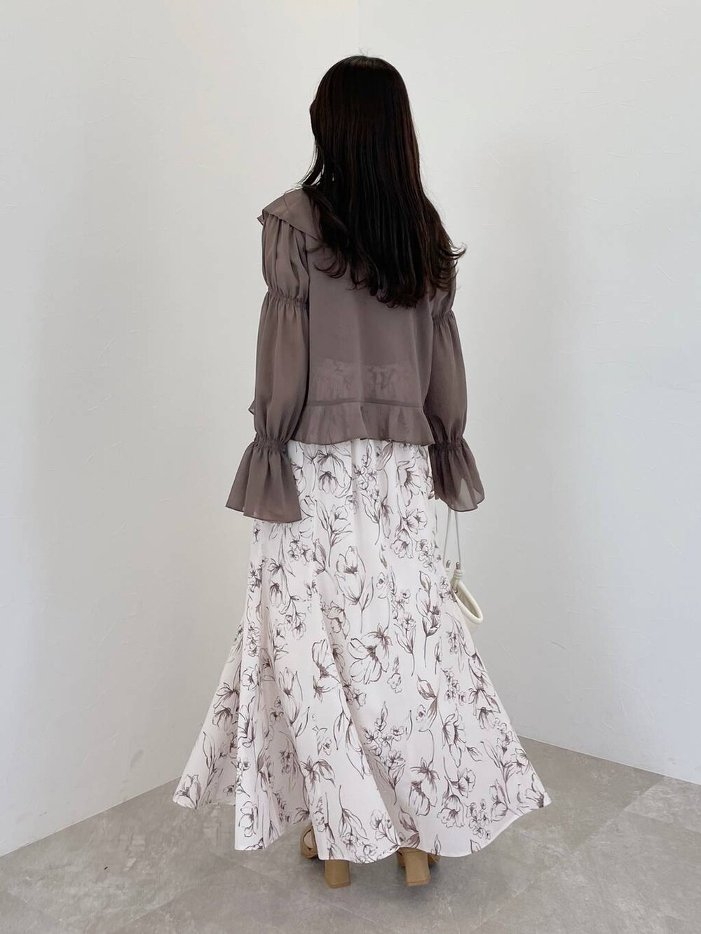 ピンク系のタンクトップ、ブラウン系のシャツ/ブラウス、ベージュ系のパンプスを着用したレディースの冬コーディネートの2枚目の写真