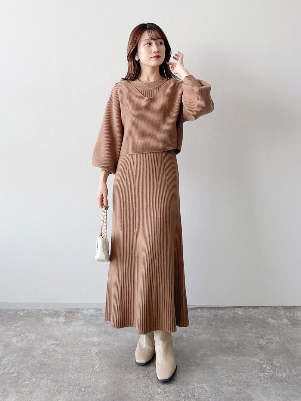 ブラウン系のワンピース、ホワイト系のショルダーバッグ、ベージュ系のブーツを着用したレディースの秋コーディネートの3枚目の写真