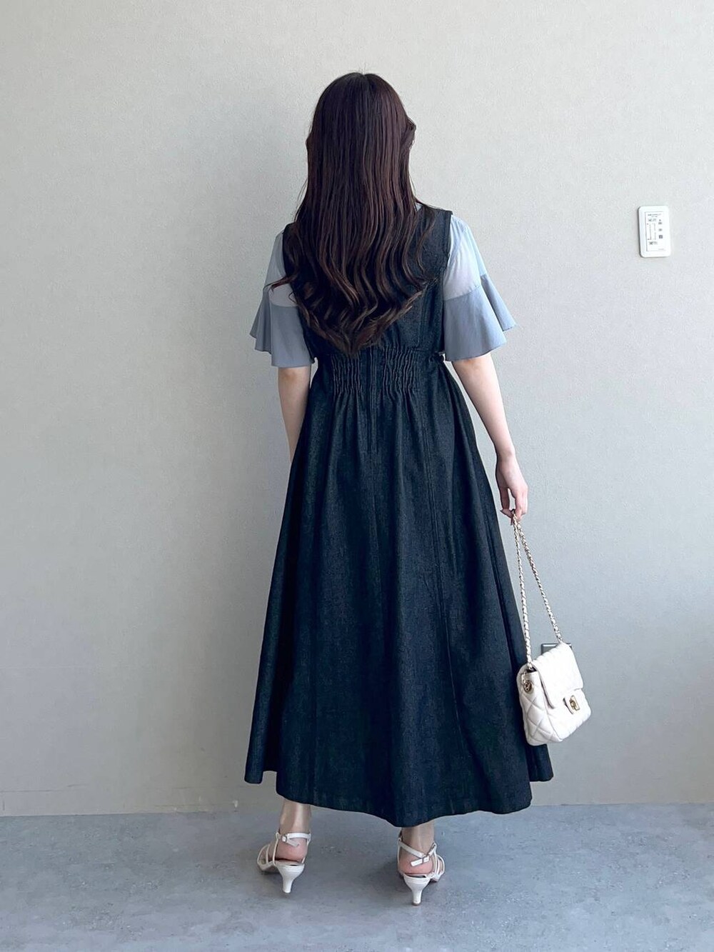 ブルー系のTシャツ/カットソー、ホワイト系のショルダーバッグ、ブラック系のジャンパースカートを着用したレディースの夏コーディネートの3枚目の写真