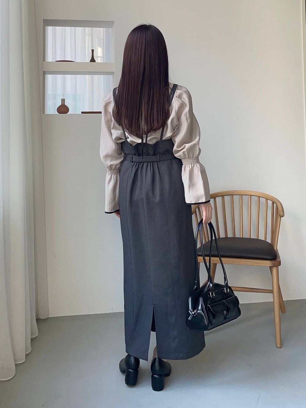 ブラック系のハンドバッグ、ベージュ系のシャツ/ブラウス、ブラック系のパンプスを着用したレディースの春コーディネートの2枚目の写真