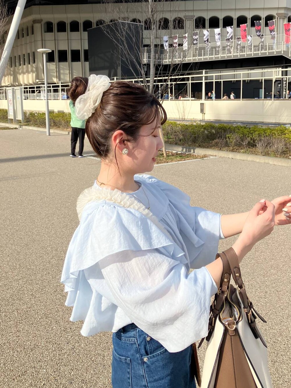 ブルー系のシャツ/ブラウス、ホワイト系のトートバッグ、その他のスマホケース/カバーを着用したレディースの春コーディネートの3枚目の写真