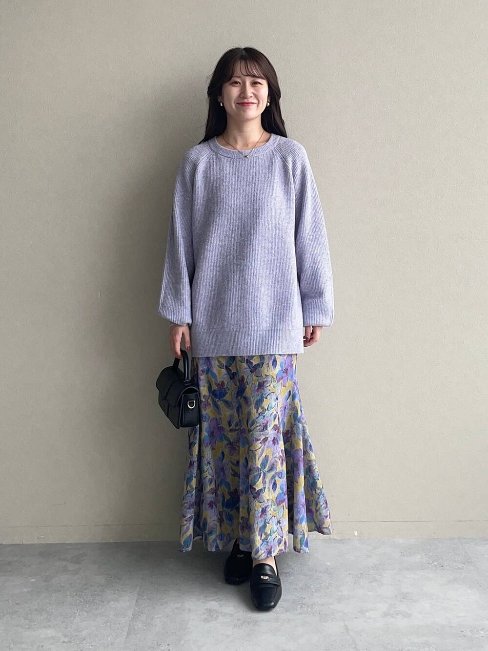 イエロー系のスカート、ベージュ系のマウンテンパーカー、パープル系のニット/セーターを着用したレディースの秋コーディネートの3枚目の写真