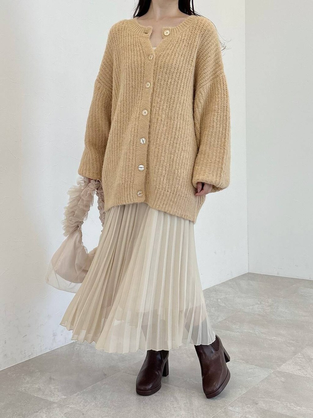 ブラウン系のブーツ、ベージュ系のショルダーバッグ、ベージュ系のカーディガン/ボレロを着用したレディースの冬コーディネートの4枚目の写真