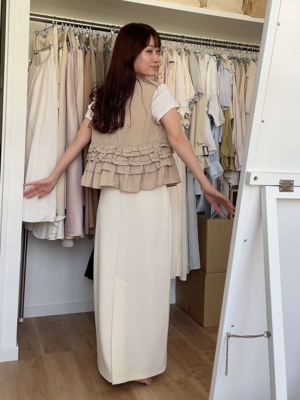 その他のトートバッグ、ベージュ系のベスト、ホワイト系のスカートを着用したレディースの夏コーディネートの3枚目の写真