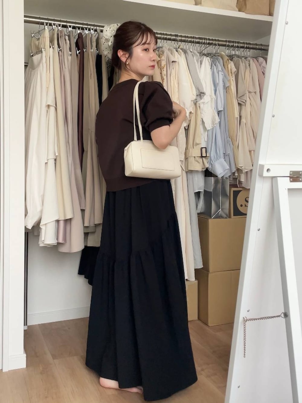 ブラウン系のカーディガン/ボレロ、ブラック系のワンピースを着用したレディースの夏コーディネートの2枚目の写真