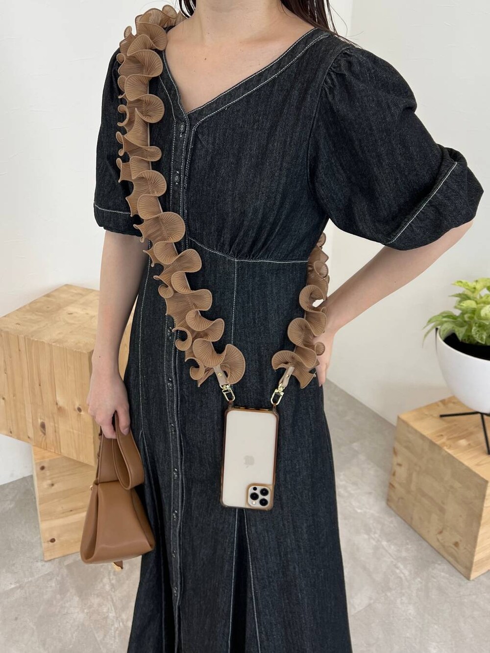 ブラウン系のショルダーバッグ、ブラック系のワンピース、ホワイト系のサンダルを着用したレディースの春コーディネートの3枚目の写真