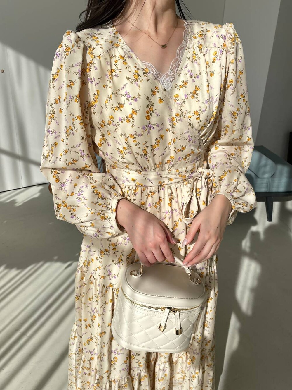 ホワイト系のタンクトップ、ホワイト系のショルダーバッグ、ベージュ系のパンプスを着用したレディースの冬コーディネートの4枚目の写真