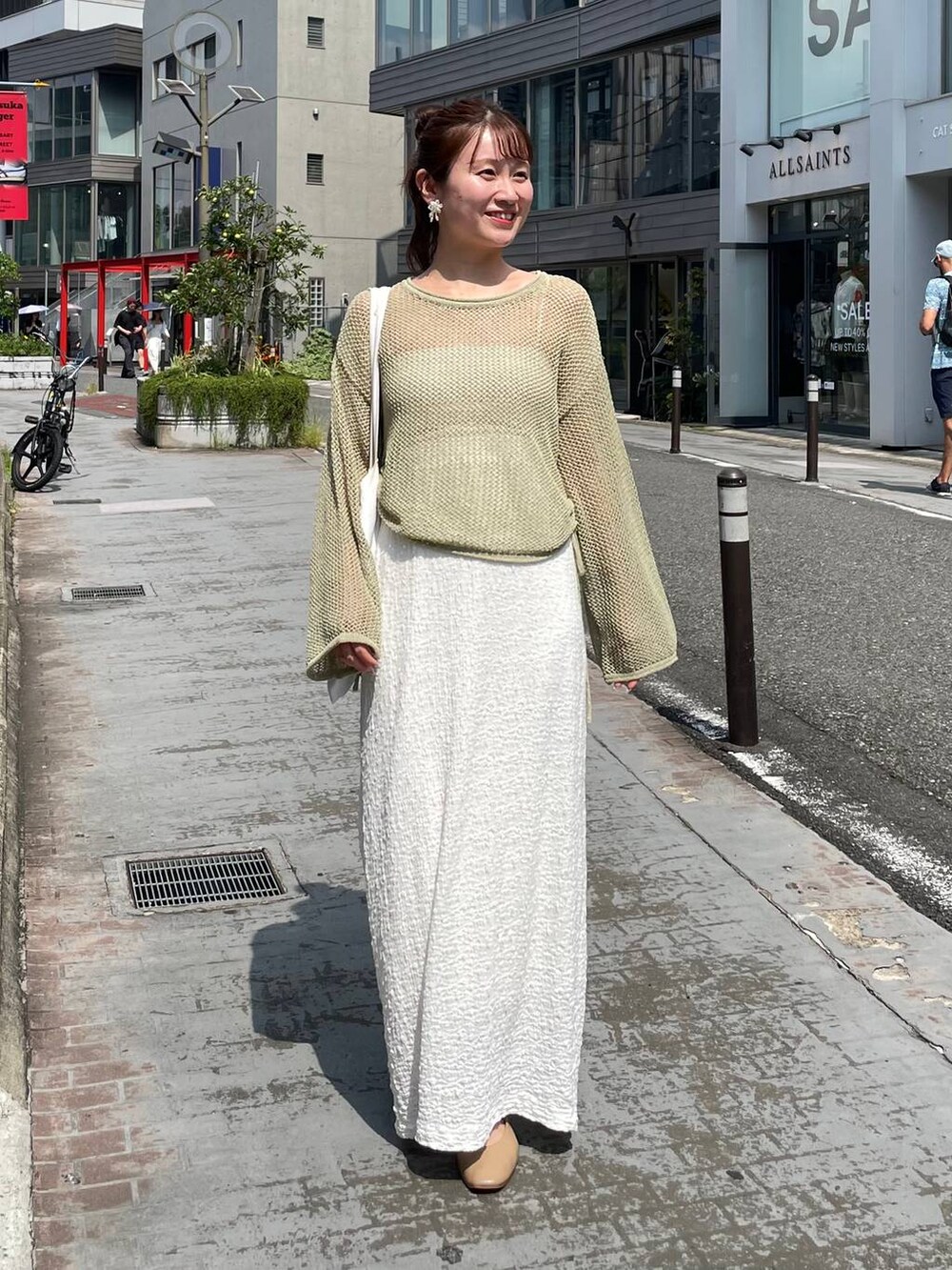 ホワイト系のスカート、グリーン系のニット/セーターを着用したレディースの夏コーディネートの2枚目の写真