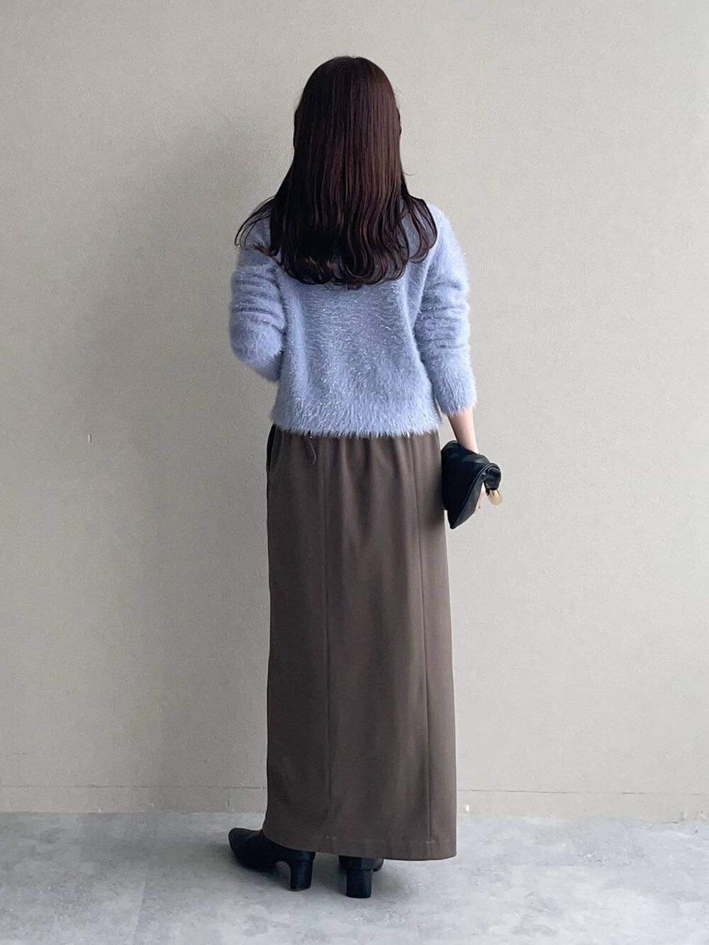 ブラック系のピーコート、ブラック系のハンドバッグ、ブラック系のブーツを着用したレディースの秋コーディネートの4枚目の写真