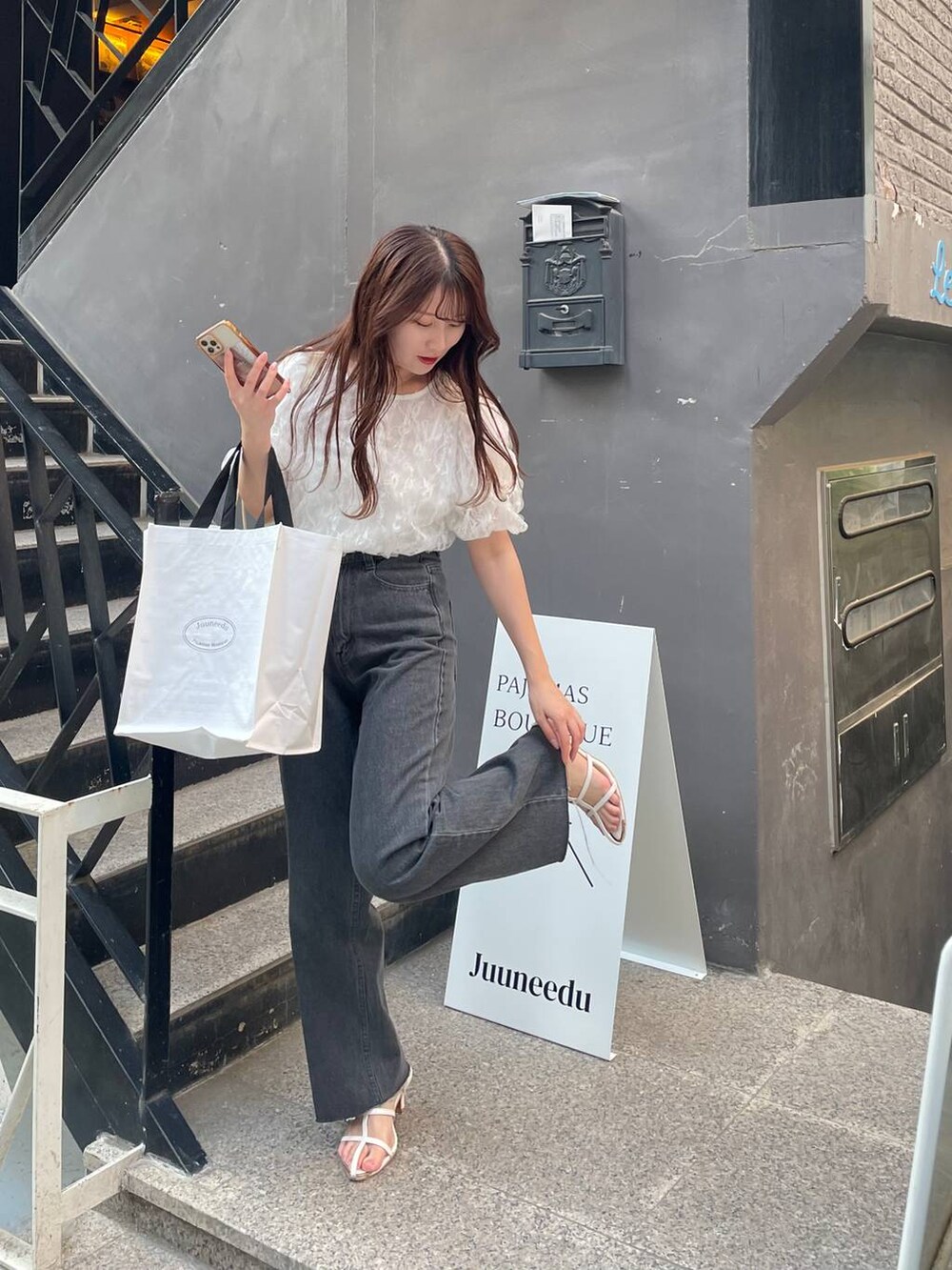 ホワイト系のシャツ/ブラウス、ホワイト系のサンダル、ブラック系のデニムパンツを着用したレディースの夏コーディネートの3枚目の写真