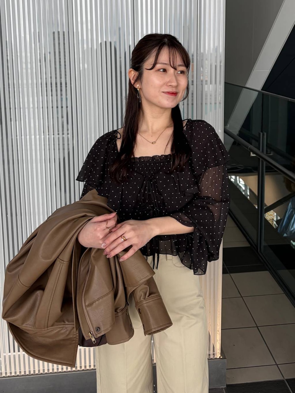 ブラウン系のボストンバッグ、ブラウン系のブルゾン、ブラック系のシャツ/ブラウスを着用したレディースの春コーディネートの5枚目の写真