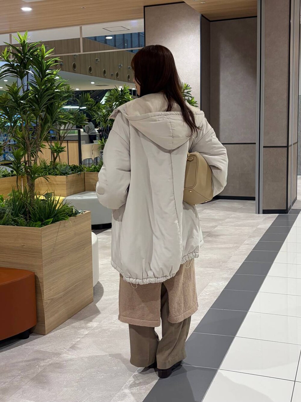 ゴールド系のボストンバッグ、ピンク系のワンピースを着用したレディースの冬コーディネートの4枚目の写真