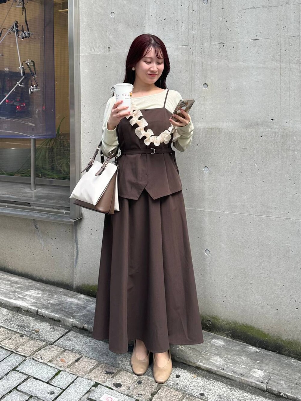 ブラウン系のワンピース、ホワイト系のTシャツ/カットソー、ホワイト系のスマホグッズを着用したレディースの冬コーディネートの3枚目の写真