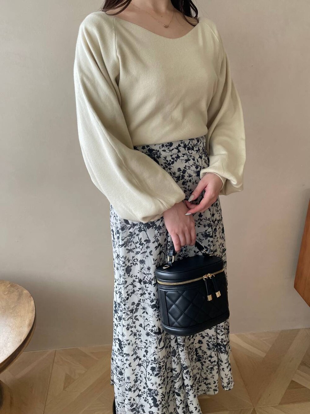 ブラック系のブーツ、ブラック系のショルダーバッグ、ホワイト系のワンピースを着用したレディースの冬コーディネートの6枚目の写真