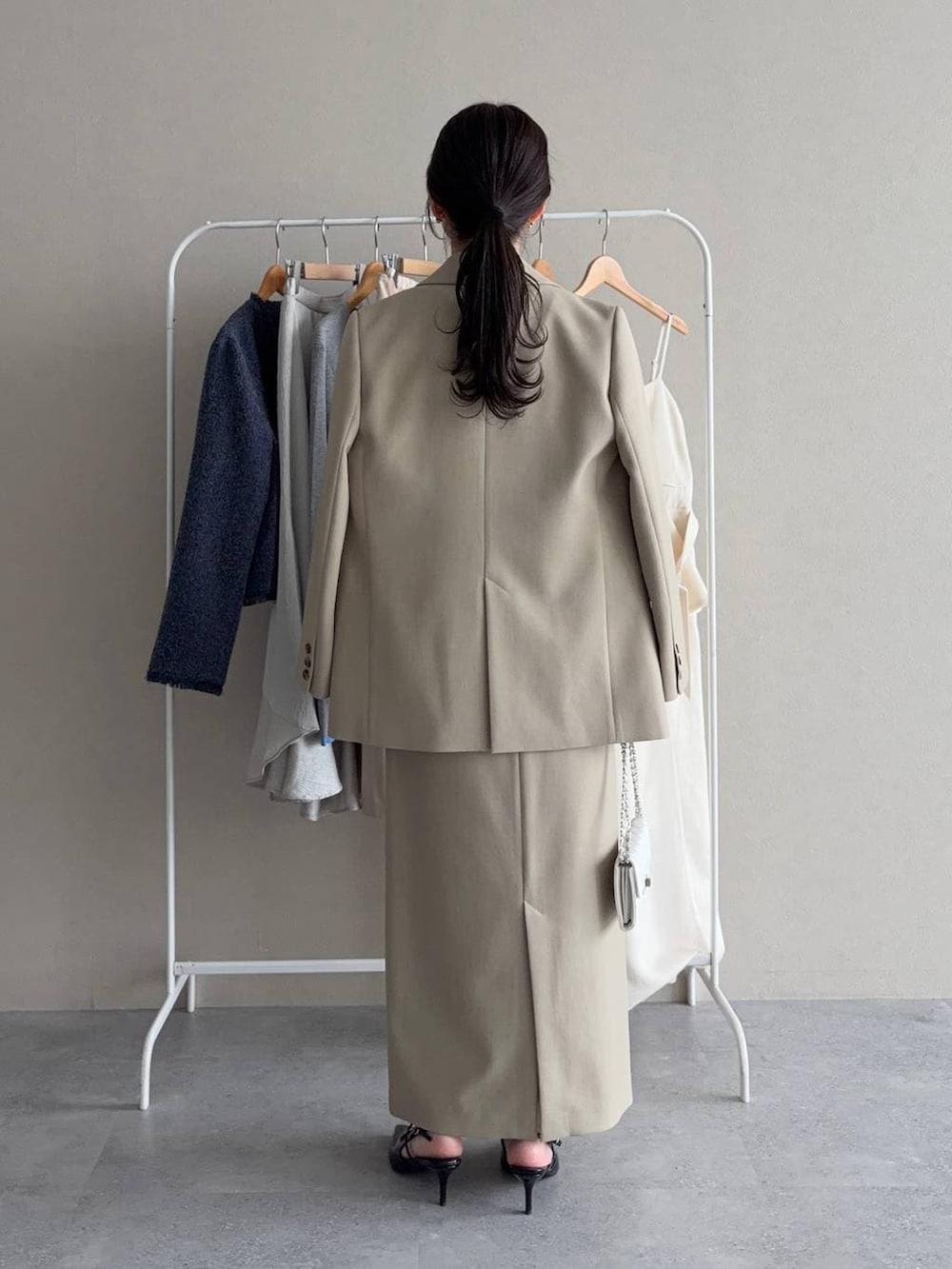 ベージュ系のテーラードジャケット、ベージュ系のスカート、ホワイト系のシャツ/ブラウスを着用したレディースの春コーディネートの2枚目の写真