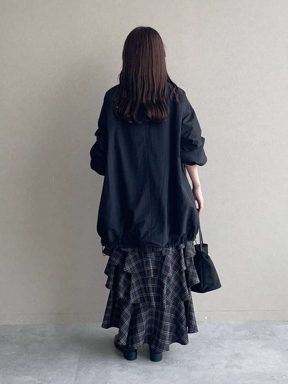 グレー系のニット/セーター、ブラウン系のスカート、ブラック系のローファーを着用したレディースの秋コーディネートの2枚目の写真