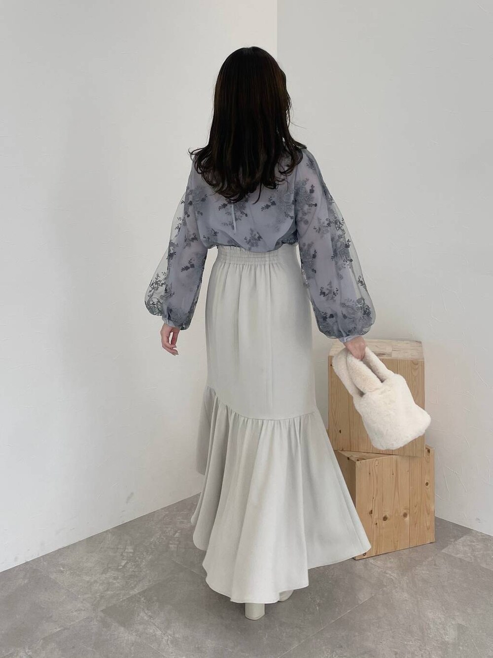 ホワイト系のブーツ、ブルー系のシャツ/ブラウス、ホワイト系のハンドバッグを着用したレディースの冬コーディネートの2枚目の写真