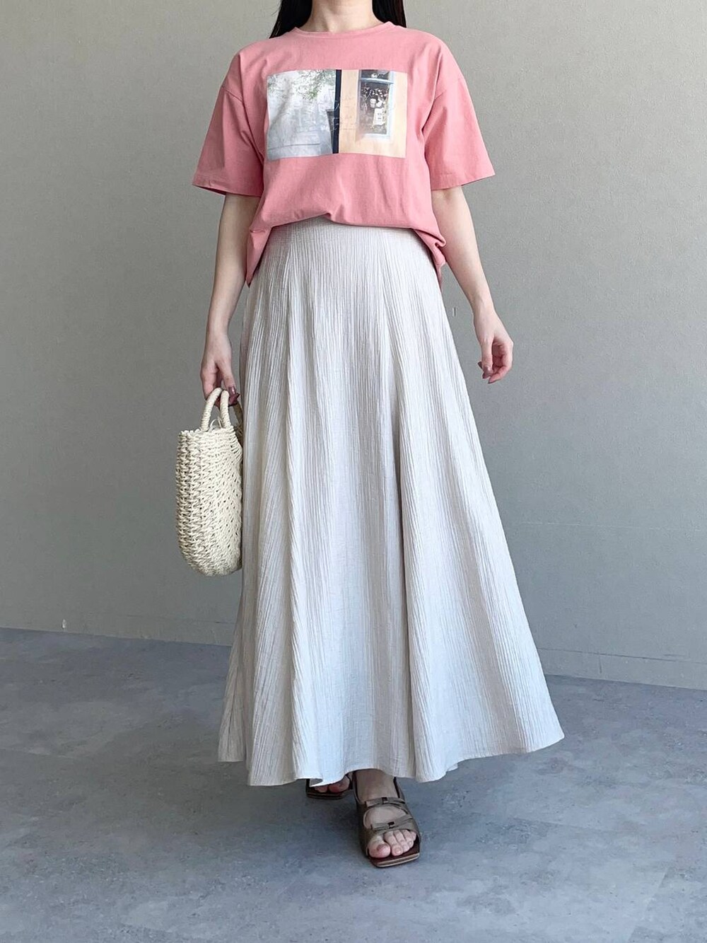 ブラウン系のサンダル、ピンク系のTシャツ/カットソー、ベージュ系のスカートを着用したレディースの春コーディネートの4枚目の写真