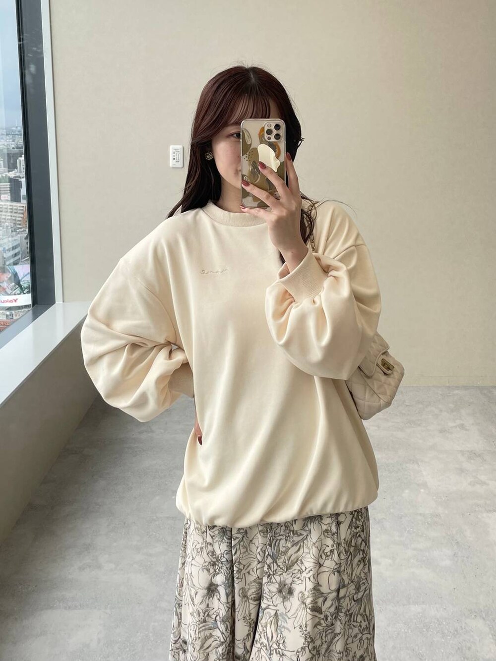 ブラウン系のノーカラーコート、ホワイト系のスカート、ホワイト系のショルダーバッグを着用したレディースの秋コーディネートの6枚目の写真