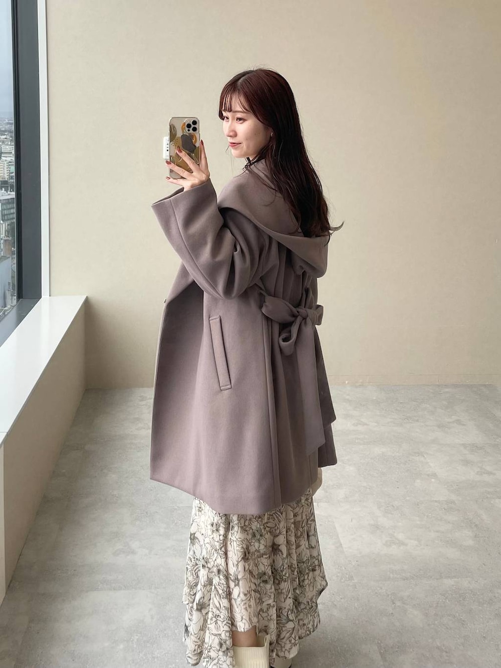 ブラウン系のノーカラーコート、ホワイト系のスカート、ホワイト系のショルダーバッグを着用したレディースの秋コーディネートの3枚目の写真