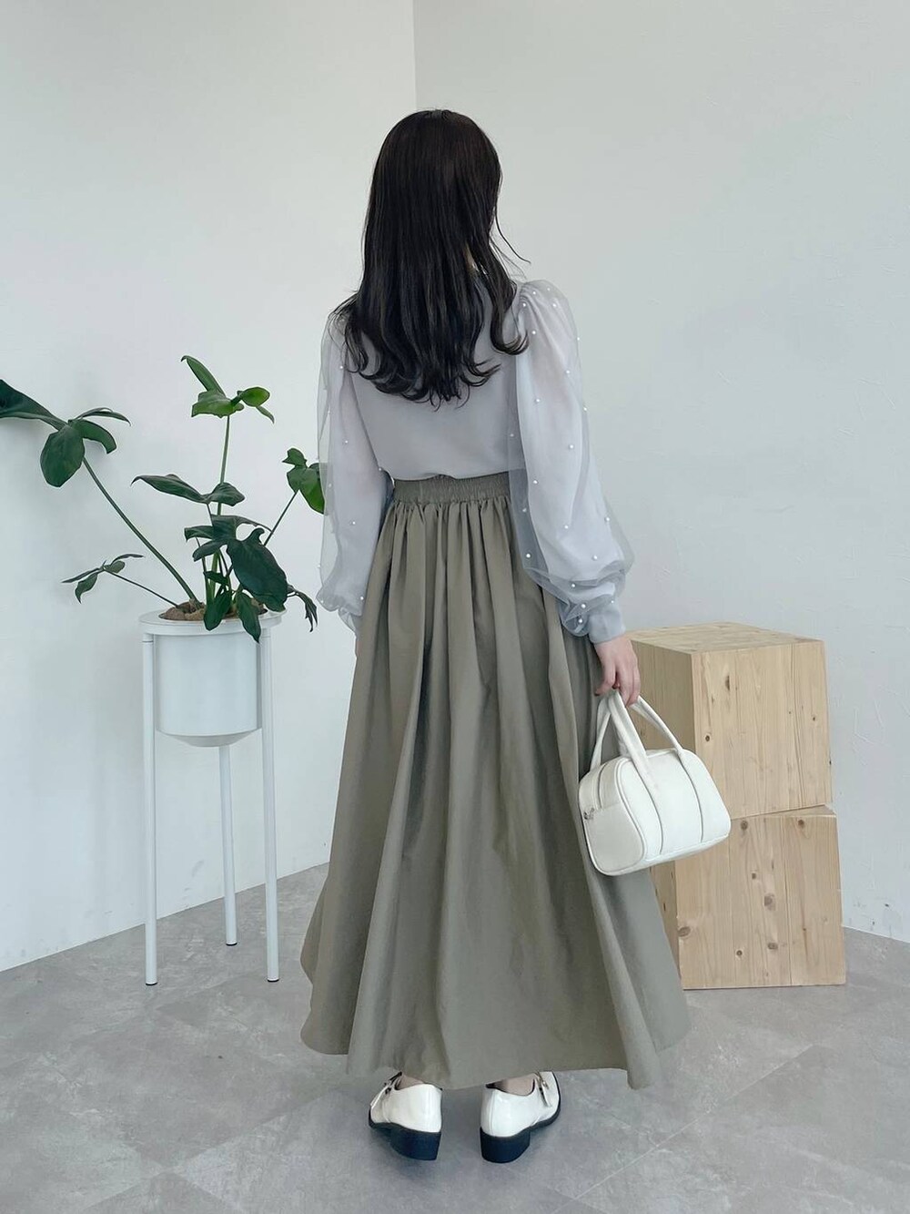 ホワイト系のボストンバッグ、グレー系のTシャツ/カットソー、ベージュ系のスカートを着用したレディースの夏コーディネートの2枚目の写真