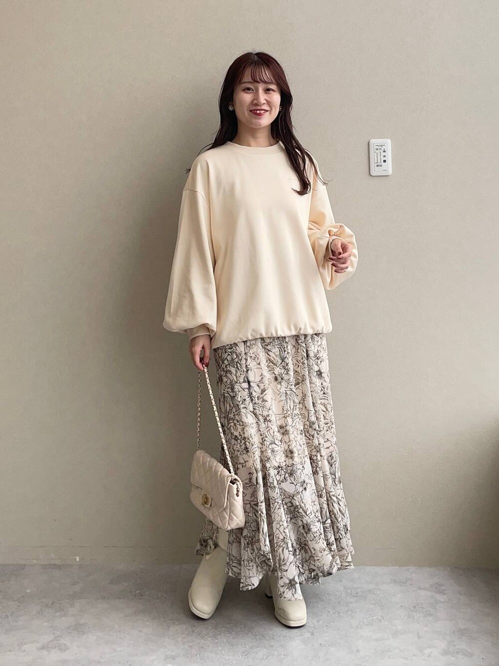 ブラウン系のノーカラーコート、ホワイト系のスカート、ホワイト系のショルダーバッグを着用したレディースの秋コーディネートの4枚目の写真