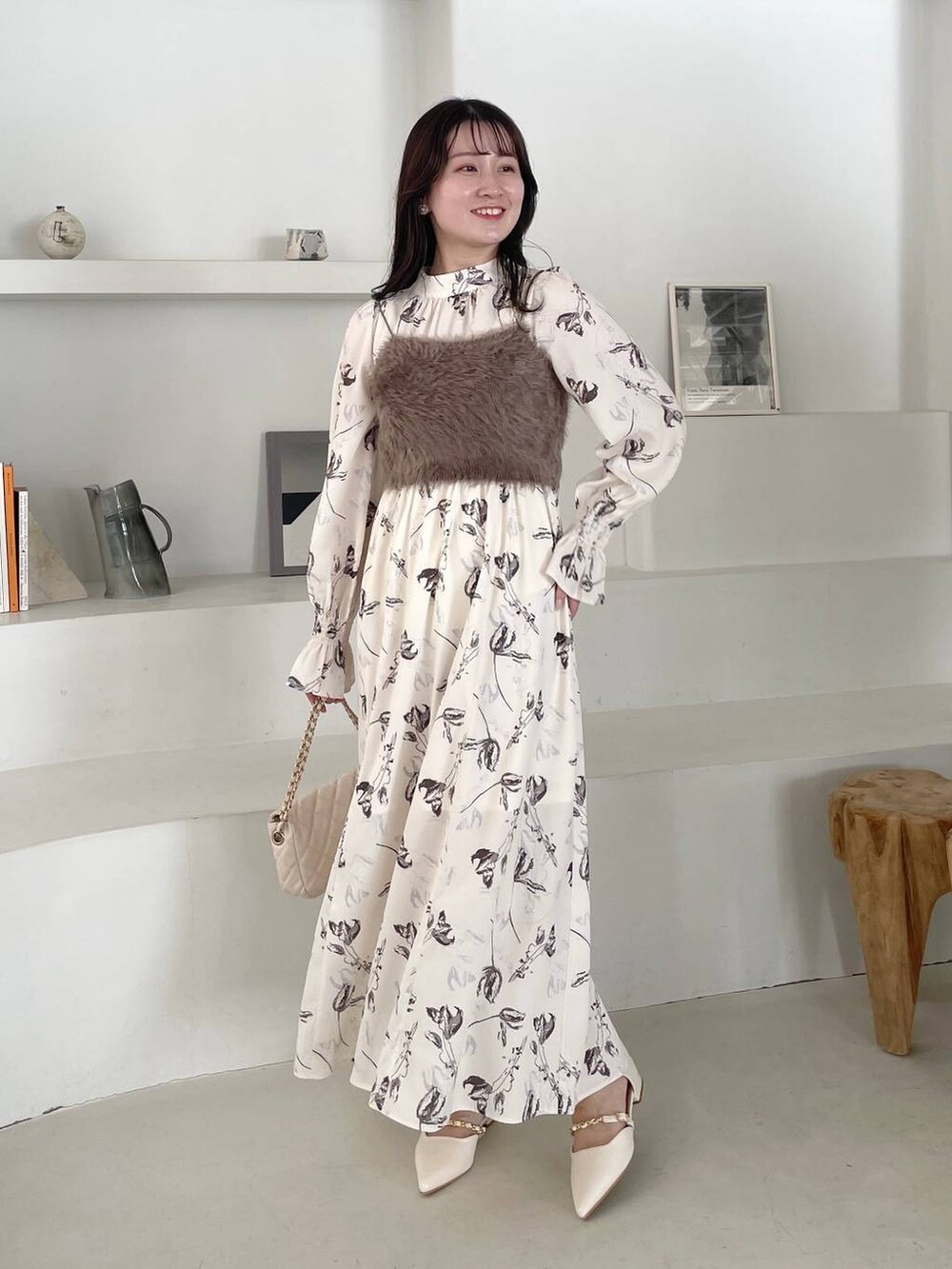 ホワイト系のショルダーバッグ、ホワイト系のパンプス、ホワイト系のワンピースを着用したレディースの冬コーディネートの4枚目の写真