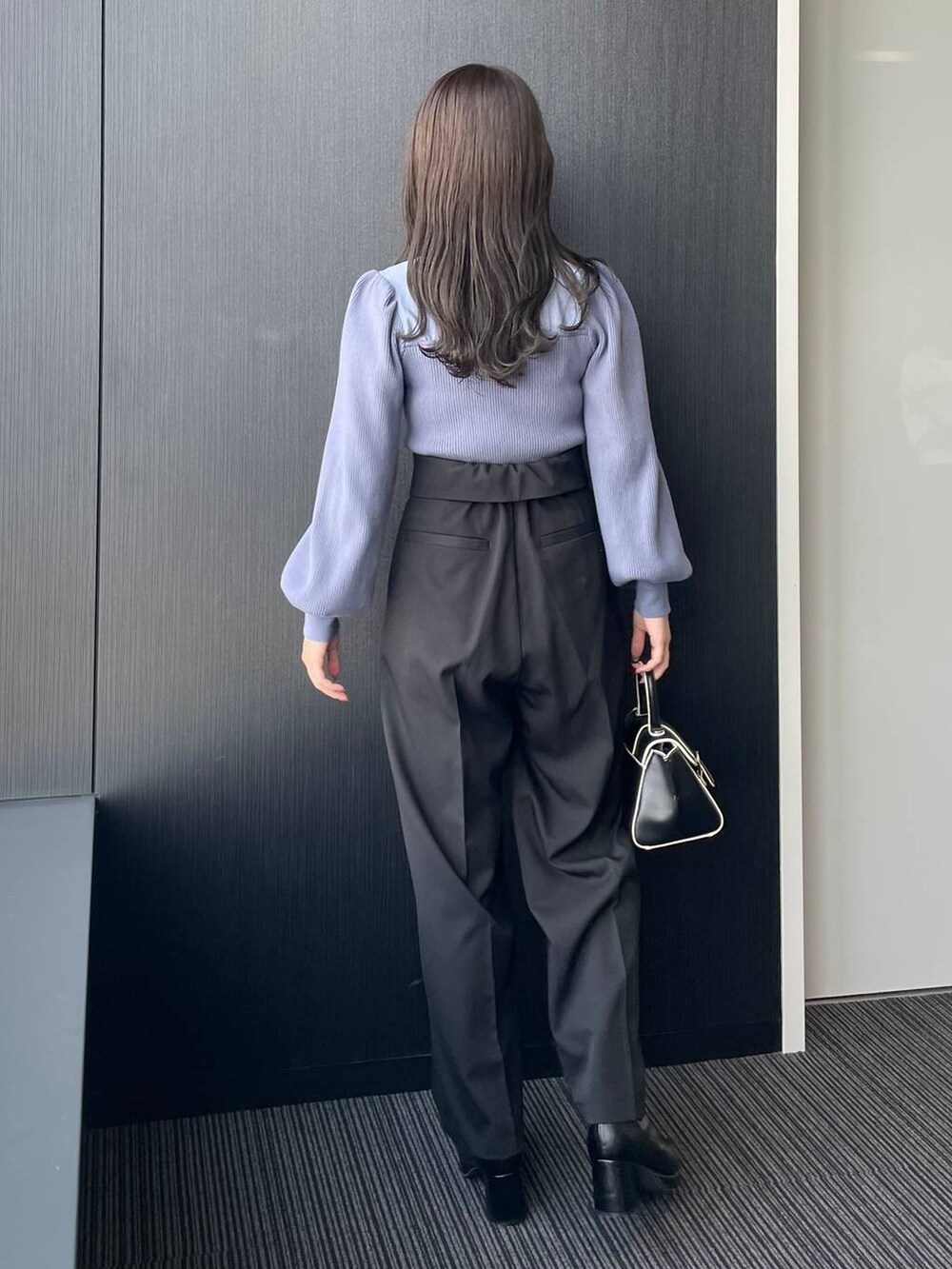 ブラック系のハンドバッグ、ブラック系のブーツ、ブラック系のその他パンツを着用したレディースの秋コーディネートの3枚目の写真