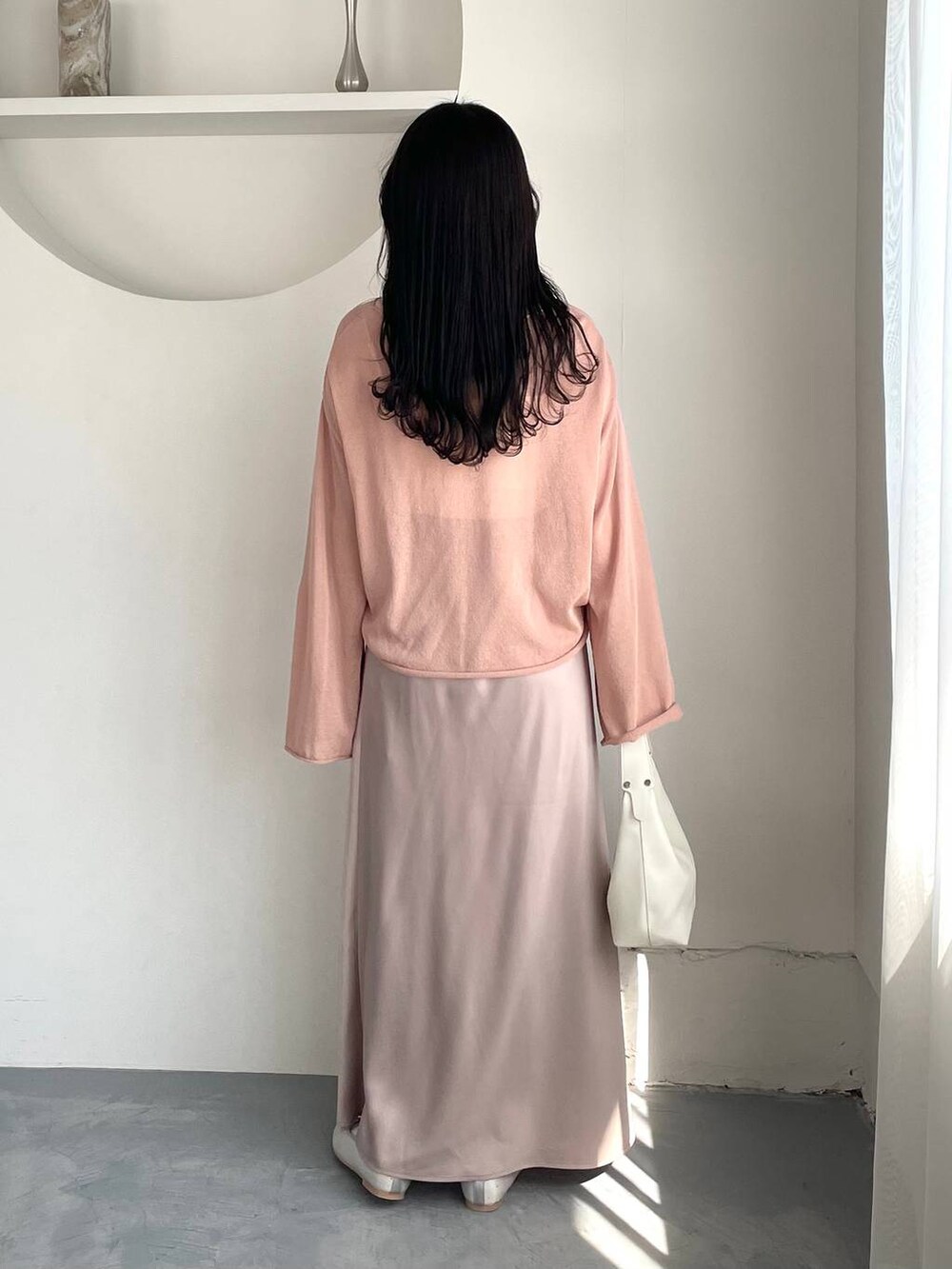 ピンク系のニット/セーター、シルバー系のバレエシューズ、ホワイト系のキャミソールを着用したレディースの春コーディネートの2枚目の写真