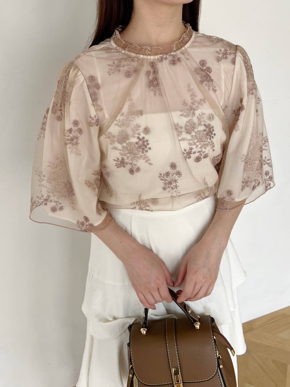 ホワイト系のスカート、ホワイト系のシャツ/ブラウス、ゴールド系のパンプスを着用したレディースの夏コーディネートの3枚目の写真