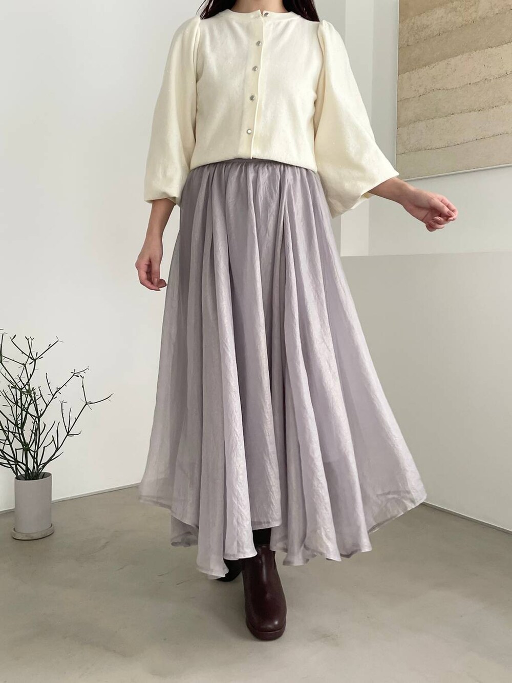 ブラウン系のブーツ、ホワイト系のカーディガン/ボレロ、ブラウン系のハンドバッグを着用したレディースの秋コーディネートの5枚目の写真