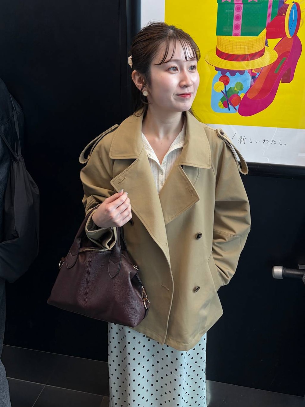 ホワイト系のスカート、ブラウン系のボストンバッグ、ベージュ系のトレンチコートを着用したレディースの冬コーディネートの4枚目の写真