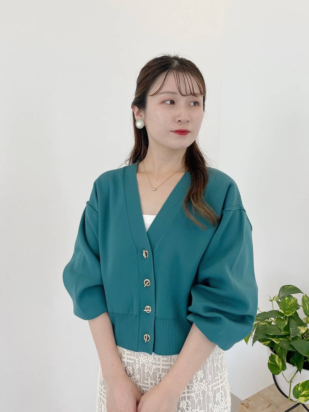 ブラック系のハンドバッグ、ブラック系のパンプス、グリーン系のカーディガン/ボレロを着用したレディースの秋コーディネートの3枚目の写真