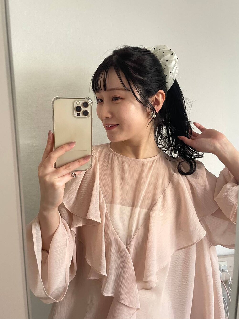 ピンク系のヘアゴムを着用したレディースの春コーディネートの2枚目の写真
