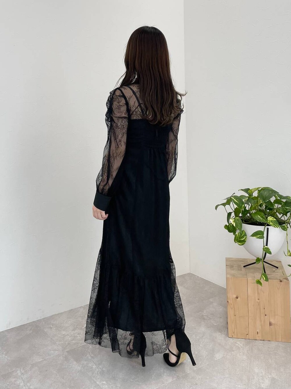 ブラック系のパンプス、ブラック系のボストンバッグ、ブラック系のドレスを着用したレディースの冬コーディネートの2枚目の写真