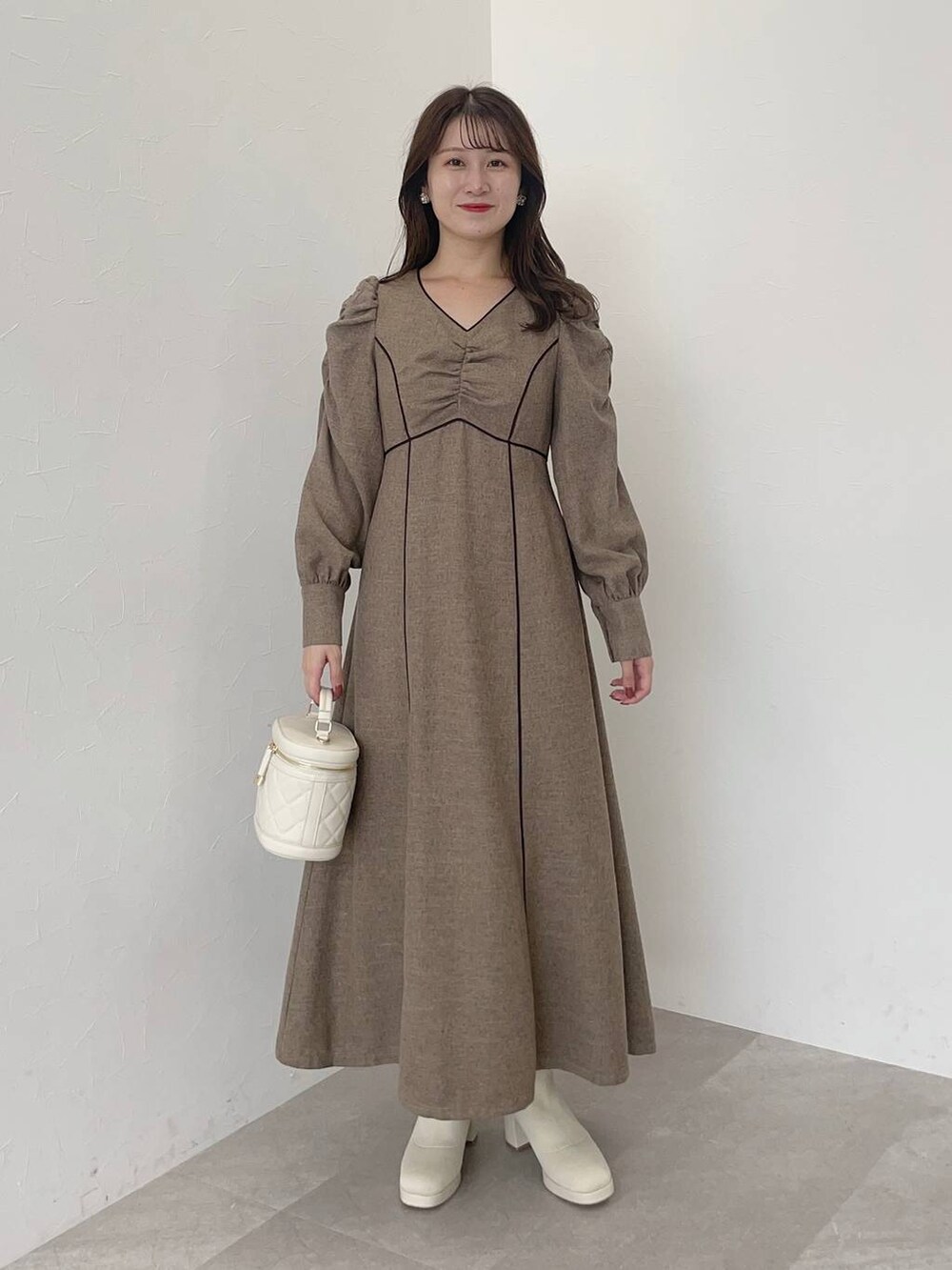 ブラック系のその他アウター、ホワイト系のブーツ、ホワイト系のショルダーバッグを着用したレディースの秋コーディネートの3枚目の写真