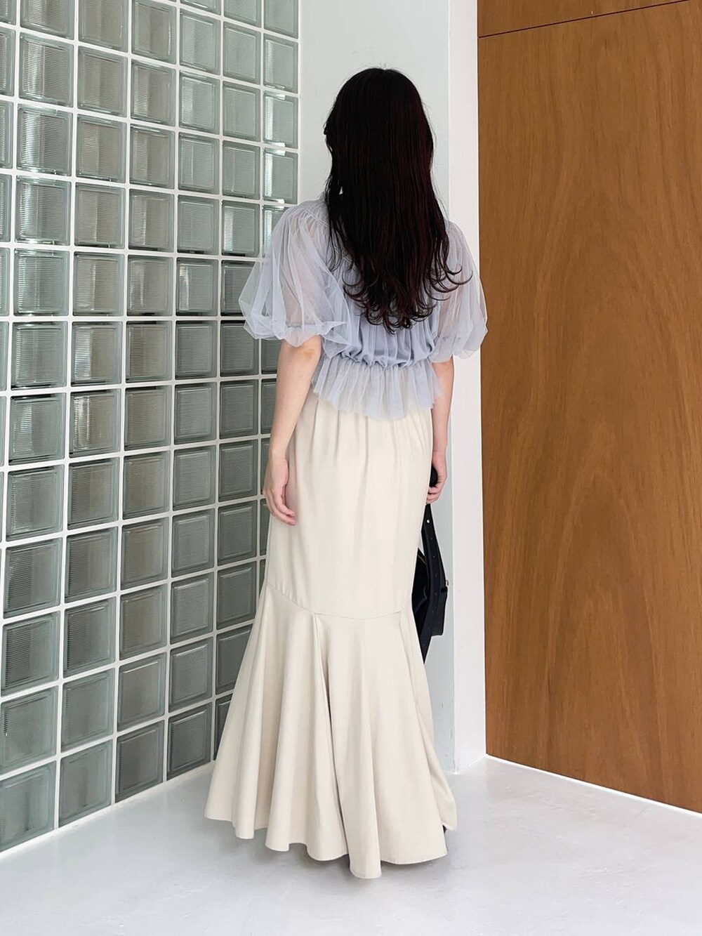 ブラック系のショルダーバッグ、ブラック系のサンダル、ブルー系のシャツ/ブラウスを着用したレディースの夏コーディネートの2枚目の写真