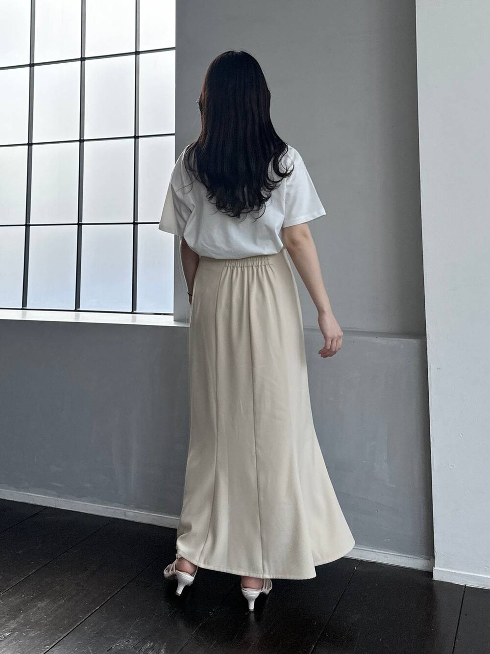ホワイト系のTシャツ/カットソー、ホワイト系のサンダル、ベージュ系のスカートを着用したレディースの春コーディネートの2枚目の写真