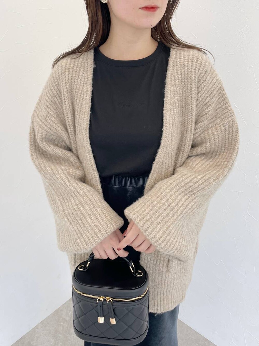 ブラック系のブーツ、ブラック系のショルダーバッグ、ベージュ系のカーディガン/ボレロを着用したレディースの秋コーディネートの3枚目の写真