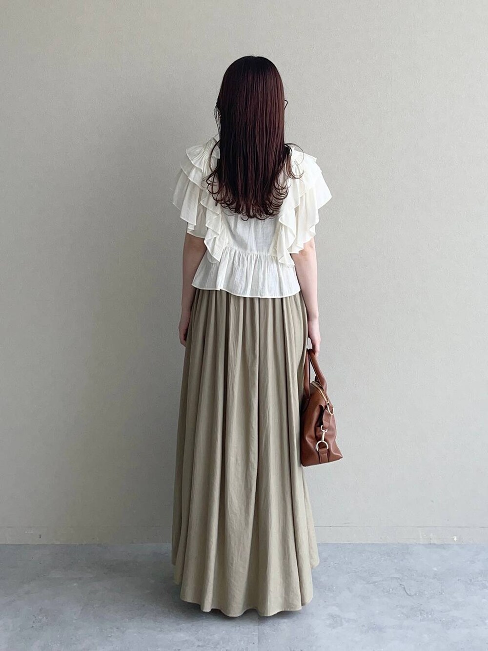 ブラウン系のサンダル、ホワイト系のシャツ/ブラウス、ブラウン系のボストンバッグを着用したレディースの春コーディネートの2枚目の写真